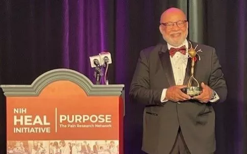 Errol Patterson accepting the Golden Neuron Award at the Annual PURPOSE Meeting