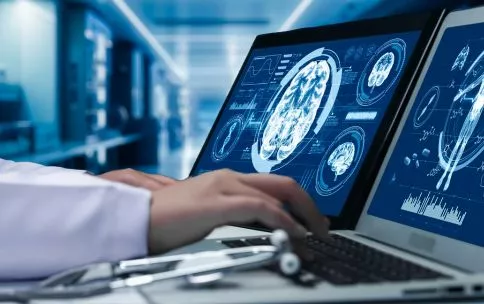 Doctor looking at an MRI image of a brain on a computer screen