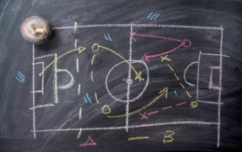 A drawing of a sports field with a play-by-play on a chalkboard