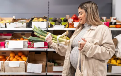Pregnant woman choosing fresh produce at the grocery store